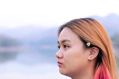 Asian teenager with colorful hair color on lake background. happiness and be yourself concept.