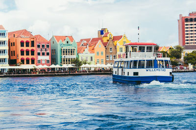 Boats in sea against sky in city