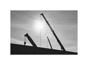 Low angle view of silhouette men against sky