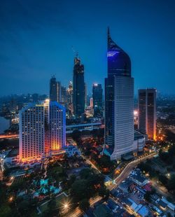 Illuminated buildings in city against sky at night