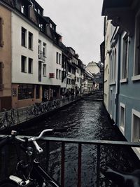 Canal amidst buildings in city against sky