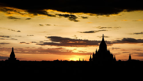 Silhouette of church against cloudy sky