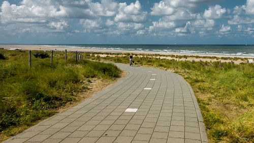 Scenic view of beach against cloudy sky