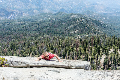 Man climbing mountain in forest 