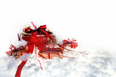 Close-up of red christmas decorations against white background