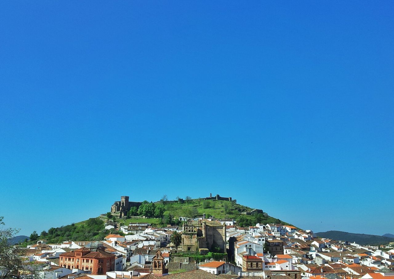 building exterior, architecture, built structure, clear sky, copy space, blue, house, residential structure, town, residential district, mountain, residential building, townscape, high angle view, city, cityscape, crowded, outdoors, day, tree