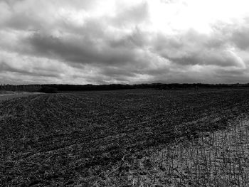 Scenic view of field against cloudy sky