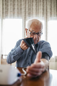 Senior man controlling his blood pressure at home