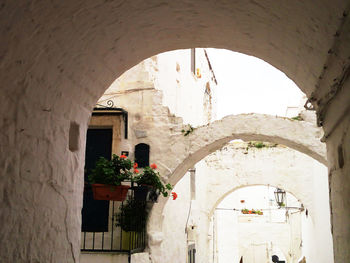 Archway of historic building against sky seen through arch window