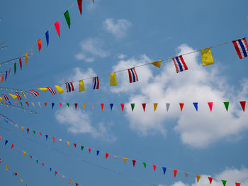 Low angle view of flags hanging against sky