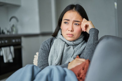 Portrait of young woman sitting at home