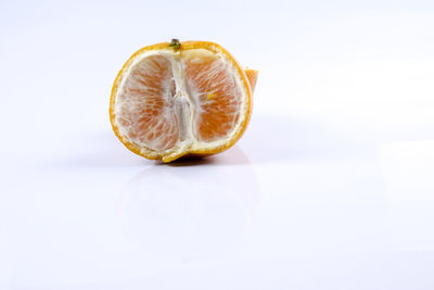 Close-up of lemon slice on table against white background