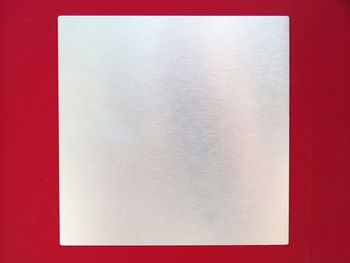 Directly above shot of white paper on table against wall