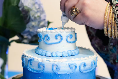 Cropped image of woman decorating cake