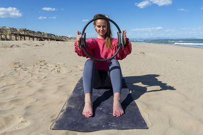 Woman with pilates ring on the beach