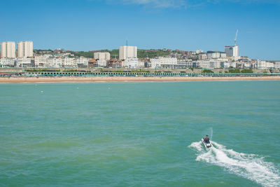 Scenic view of sea and buildings against clear sky