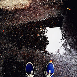 Low section of person standing on puddle