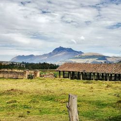 Scenic view of field and mountains against sky