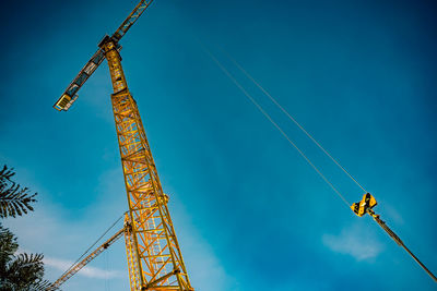 Low angle view of crane against blue sky