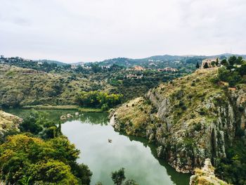 Scenic view of river amidst trees against sky