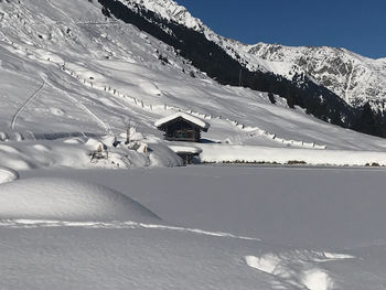 Snow covered landscape against mountain range