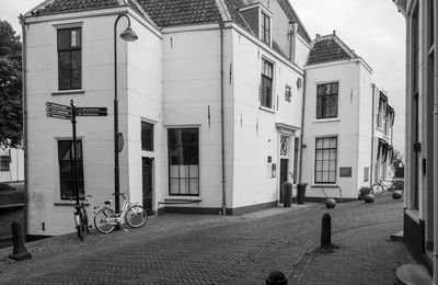Empty road amidst buildings in city