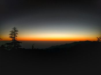 Silhouette landscape against clear sky at sunset