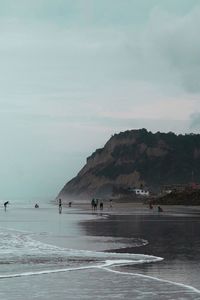 Scenic view of beach and mountains against sky