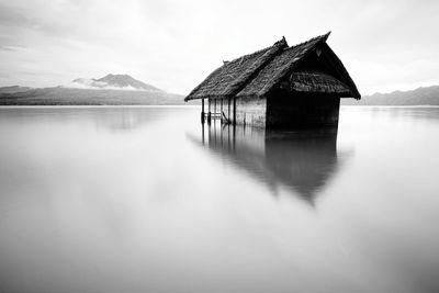 Built structure by lake against sky