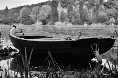 Boats moored on shore by lake