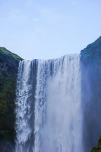 Scenic view of waterfall against sky