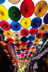 Low angle view of multi colored umbrellas hanging at market stall