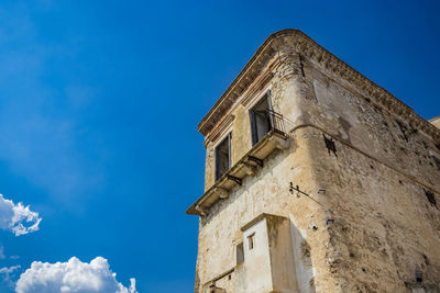 Low angle view of old building against blue sky