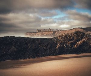 The ritz-carlton on rock formation against cloudy sky