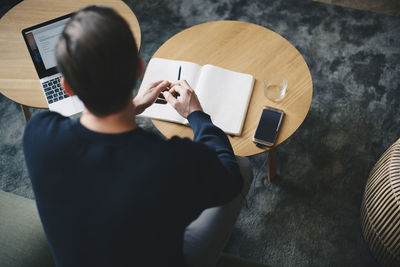 High angle view of businessman working at table in office lobby