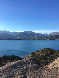 Scenic view of lake against clear blue sky