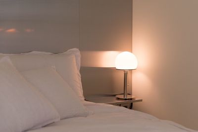 Close-up of electric lamp on bed