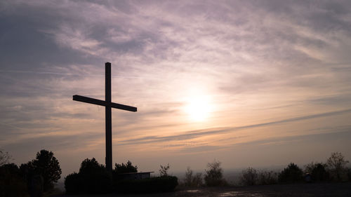 Low angle view of silhouette cross against sky during sunset