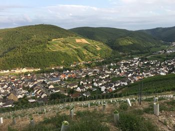 High angle view of agricultural field by houses against sky