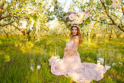 Portrait of beautiful woman with pink flower in park