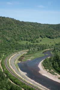 High angle view of road amidst trees against sky