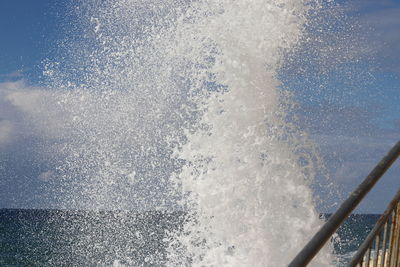 Water splashing in sea against sky