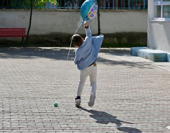 Rear view of boy catching a balloon 