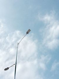 Low angle view of bird on pole against sky