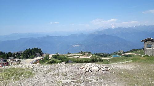 Scenic view of houses and mountains against sky