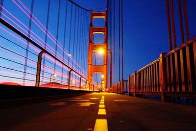 Illuminated bridge against sky at dusk