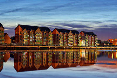 Reflection of buildings in river at sunset