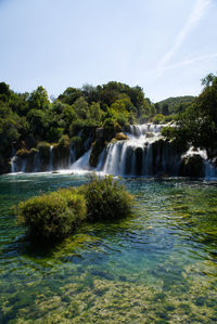 Scenic view of waterfall against sky