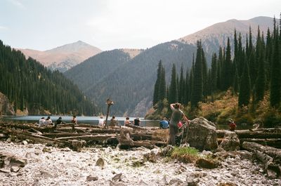 People working on mountain against sky