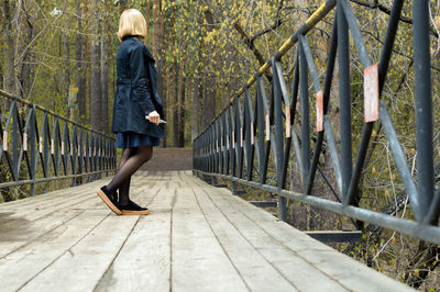 Woman walking on footbridge